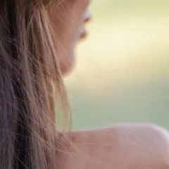 Sanfte Schulter und Haarsträhnen im Wind. Ein Hauch von Sommer, der die Frage aufwirft: wie werde ich braun mit heller haut?