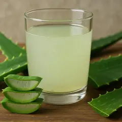 Ein Glas Aloe Vera Trinkgel mit frischen Aloe Vera Blättern. Die Wirkung von Aloe Vera Trinkgel ist bekannt für seine gesundheitlichen Vorteile.