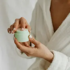 Hände mit gepflegten Nägeln öffnen eine Creme. Die positive resveratrol wirkung haut wird durch diese Pflege unterstützt.