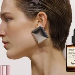 Frau mit auffälligem Ohrring und einem Fläschchen Retinol-Serum. Ab wann Retinol? Typology A61 für feine Linien.