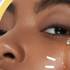 Ein Tropfen goldenes Öl mit Vitamin E wird auf die Haut aufgetragen, um sie zu pflegen.