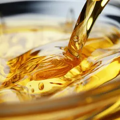 Goldener olus oil fließt in eine Schüssel und erzeugt faszinierende Wellen und Blasen.