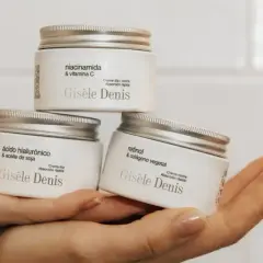 Hände halten drei Gisele Denis Cremetiegel: einer mit Niacinamid & Vitamin C, einer mit Hyaluronsäure & Sojaöl, und einer mit Retinol & pflanzlichem Kollagen.