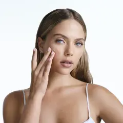 Frau trägt ein Serum auf, das die Haut mit Feuchtigkeit versorgt, um zu verhindern, dass Retinol die Haut austrocknet.