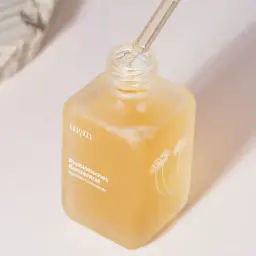 Ein Fläschchen mit probiotischem Konzentrat für die Haut. Ein Tropfen wird mit einer Pipette entnommen.