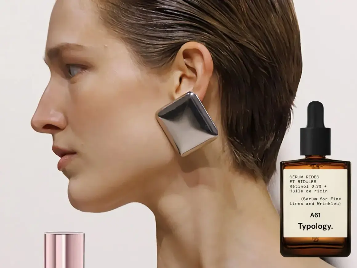 Frau mit auffälligem Ohrring und einem Fläschchen Retinol-Serum. Ab wann Retinol? Typology A61 für feine Linien.