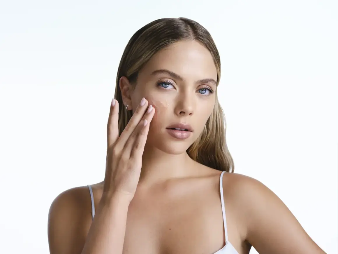 Frau trägt ein Serum auf, das die Haut mit Feuchtigkeit versorgt, um zu verhindern, dass Retinol die Haut austrocknet.