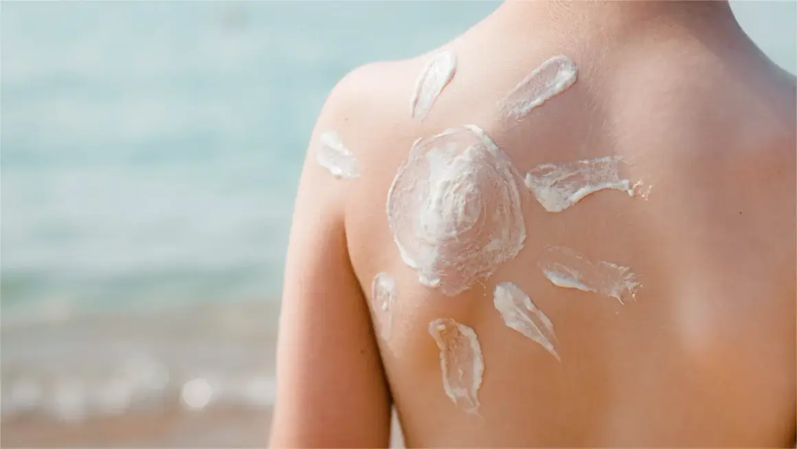 Sonnenschutz auf dem Rücken eines Kindes, geformt wie eine Sonne. Die astaxanthin wirkung schützt die Haut vor der Sonne.