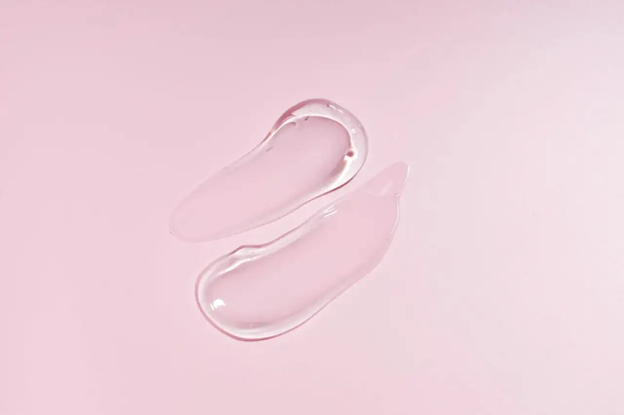 Zwei zarte, durchscheinende Tupfer auf rosa Untergrund. Sie zeigen die feuchtigkeitsspendende Wirkung von pflanzlichem Glycerin.